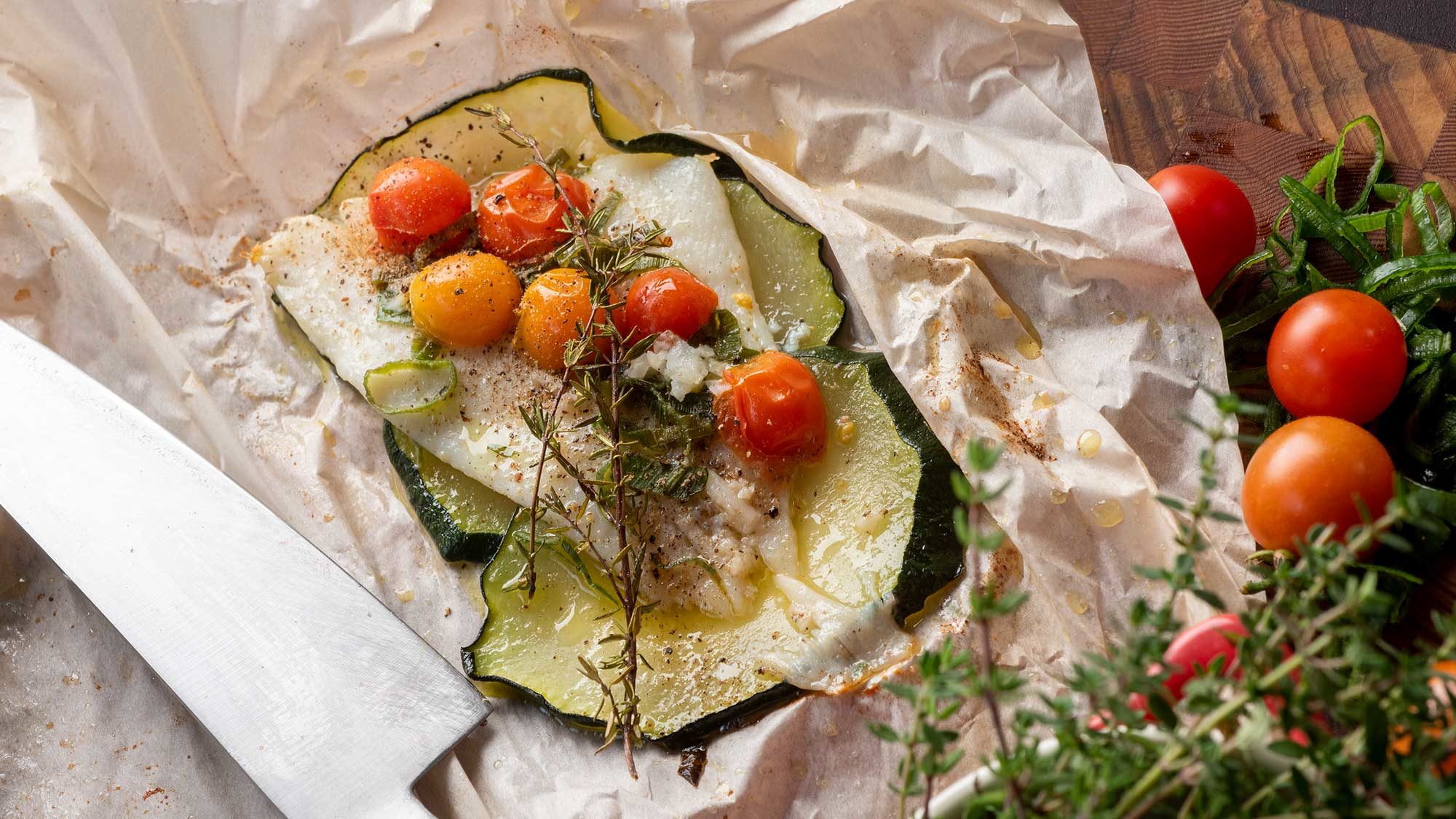 plated sole in paper with tomatoes and zucchini